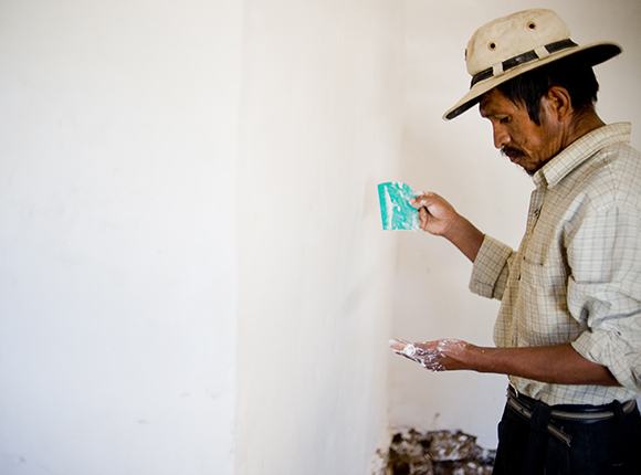 Photo of Bolivian man painting a wall