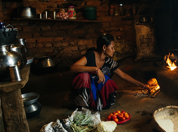Photo of Soura woman cooking by a fire