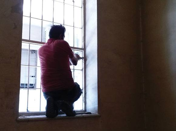 Photo of a man fixing a window