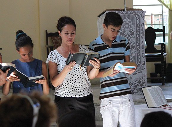 Photo of two women and a man reading Bibles